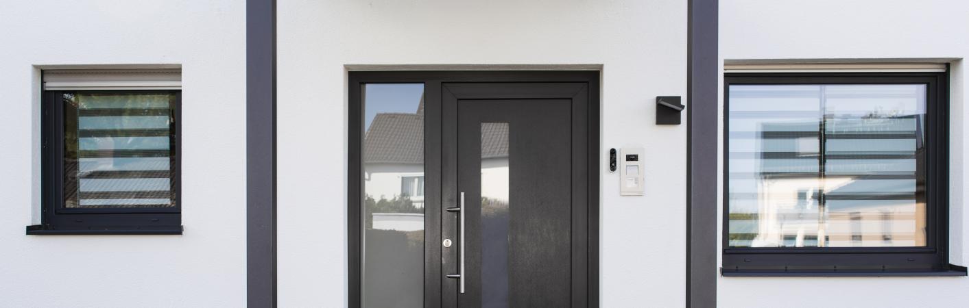 Hauseingang mit Kunststoff-Haustür anthrazit eingrahmt von zwei Kunststofffenstern in anthrazit